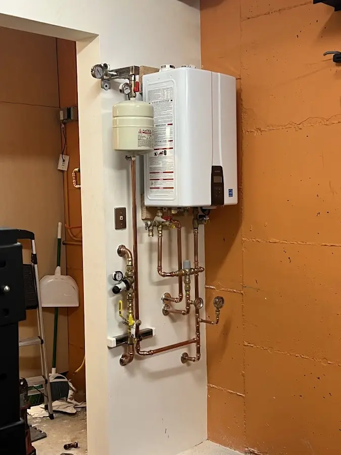 Plumbing technician inspecting water heater connections in Central